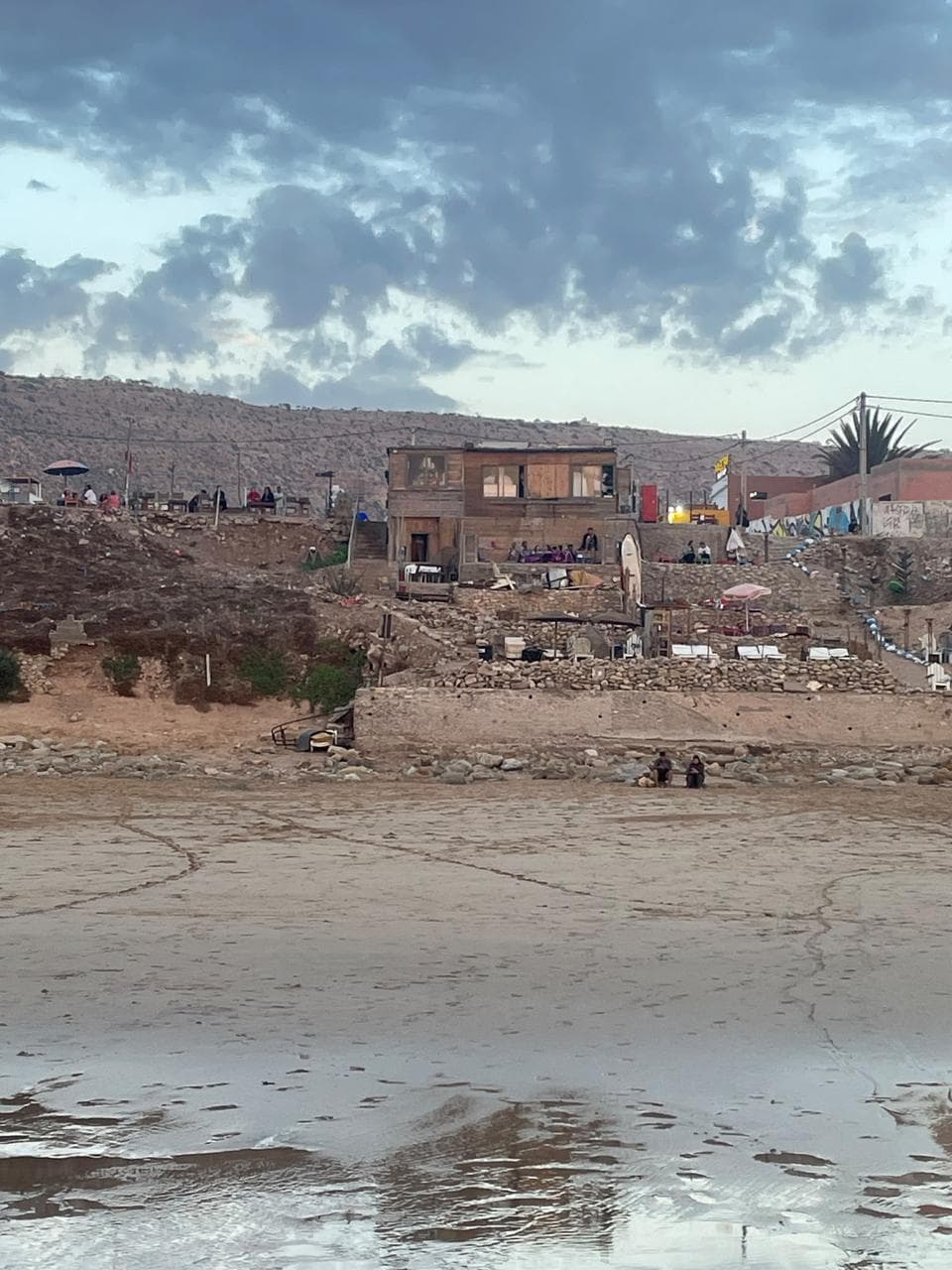 Beachfront surf shacks on the cliffs above the sand in daylight